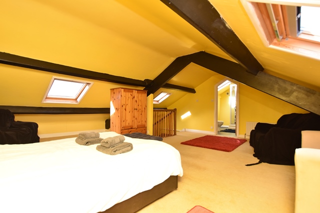 Bedroom 5: with double bed, beams, sloping ceiling and en-suite with shower cubicle and toilet.